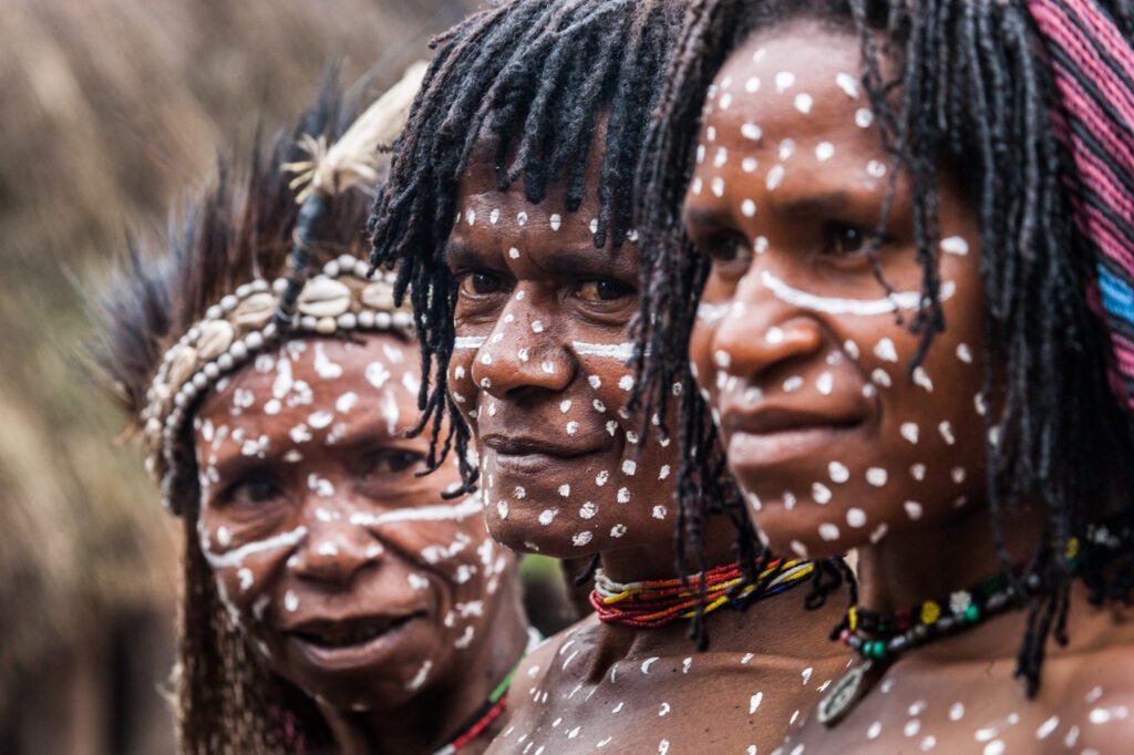 DANI VILLAGE, WAMENA, IRIAN JAYA, NEW GUINEA, INDONESIA - 15 MAY 2012: Portrait of Woman Dani tribe in ritual coloring on the body and face.