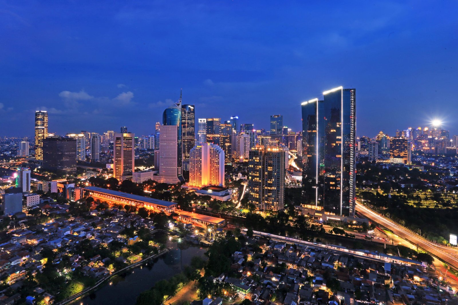 Stunning view of Jakarta's illuminated skyline at night, showcasing modern skyscrapers and vibrant urban life.