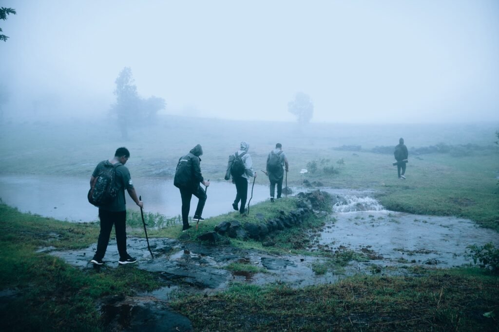 A group of hikers trekking through foggy countryside, creating a sense of adventure in misty weather.